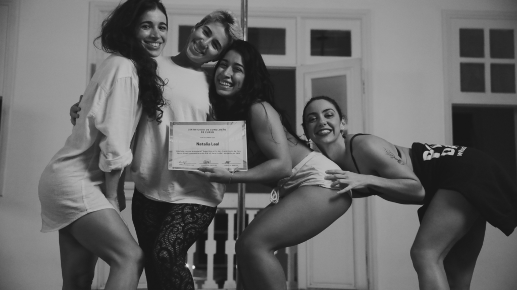 Natália Leal recebendo certificado de formação de pole dance dada por Roberta Martins, Carol Martins e Fernanda Figueira